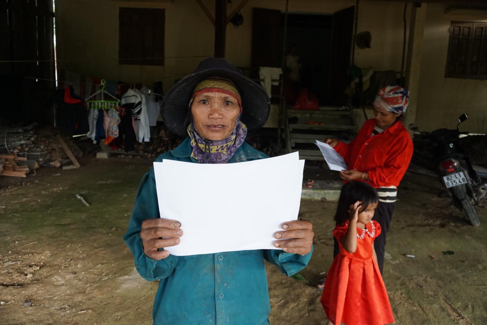 Người dân thôn Đăk Tăng nhận các tờ rơi chỉ cách ứng phó với động đất. Ảnh T.T