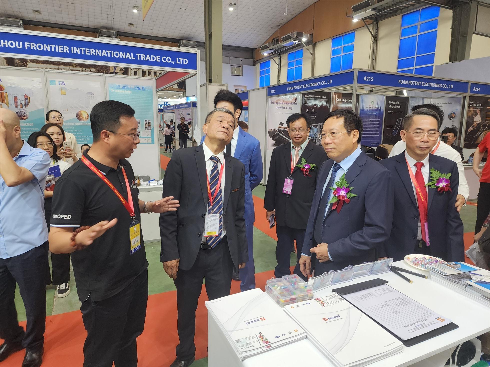 Thứ trưởng Bộ Y tế nghe giới thiệu về các loại thiết bị y tế mới tại triển lãm y dược 2023. Ảnh: Tuấn Dũng