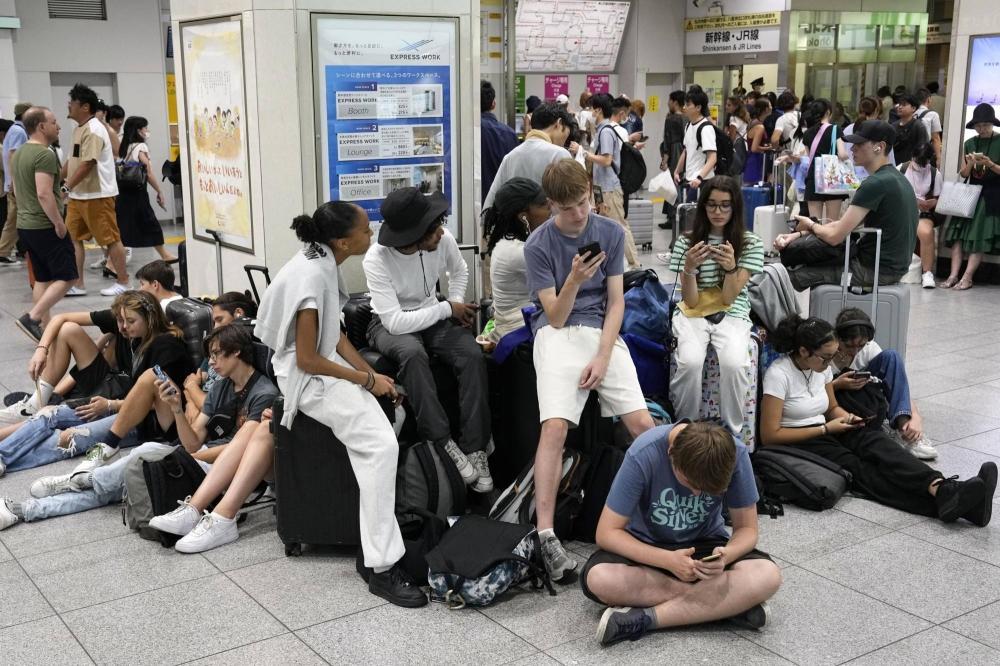 Khách du lịch bị mắc kẹt tại ga Tokyo hôm 16.8 do tàu shinkansen tạm dừng hoạt động. Ảnh: Kyodo