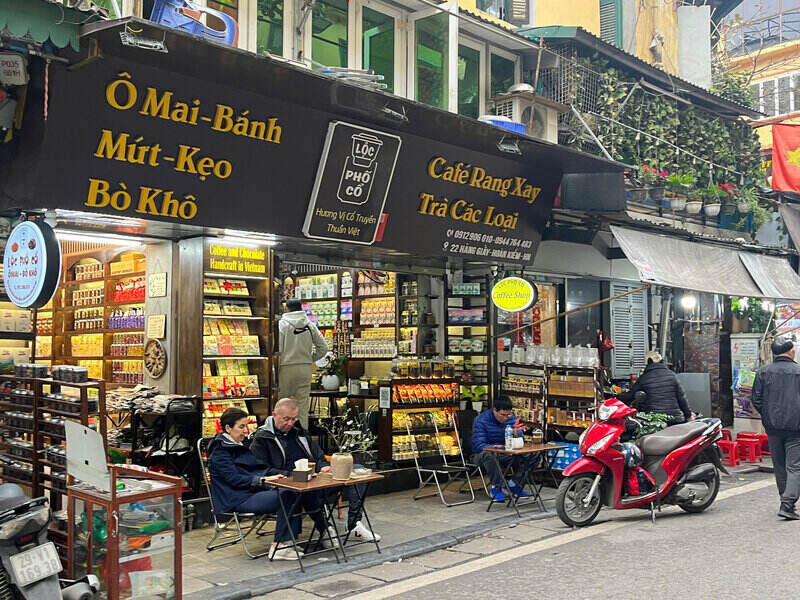 Du khách nước ngoài vui vẻ nhâm nhi thưởng thức cà phê tại Hà Nội. Ảnh: Tường Vy