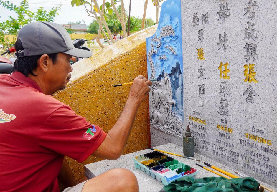 Một bia mộ được sơn, vẽ mới trong dịp Tết Thanh Minh.