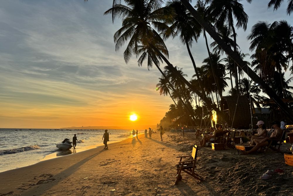 Du khách ngắm hoàng hôn bên bờ biển. Ảnh: Duy Tuấn