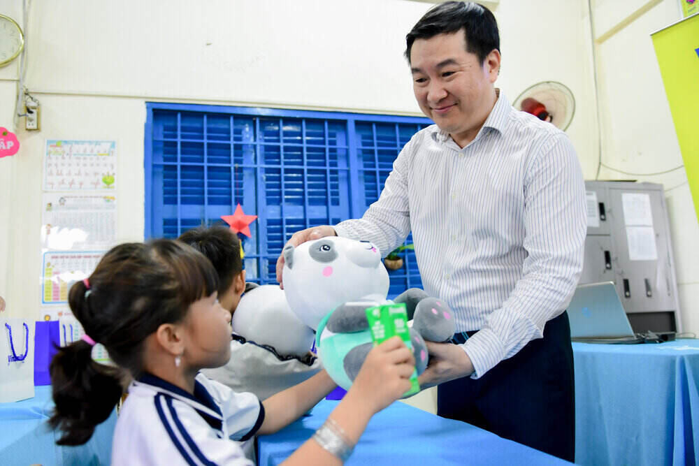 Các em học sinh đón nhận sữa, gấu bông và các món quà khác từ Vinamilk. Ảnh: Nam Anh