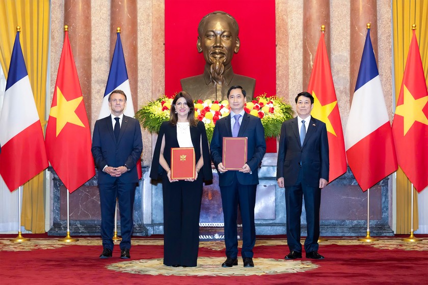 Ông Ngô Chí Dũng - Tổng Giám đốc kiêm Chủ tịch HĐQT Công ty Vaccine Việt Nam (VNVC) và bà Zainab Sadat Qayyum - Chủ tịch Sanofi vùng Đông Nam Á - Ấn Độ trao văn kiện thỏa thuận hợp tác chuyển giao công nghệ sản xuất vaccine của Sanofi tại Nhà máy Vaccine và Sinh phẩm VNVC trước sự chứng kiến của Chủ tịch nước Lương Cường và Tổng thống Pháp Emmanuel Macron. Ảnh: Hải Nam