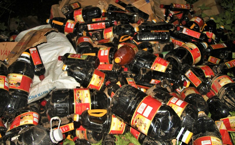 Cả nghìn chai nước mắm hết hạn nằm la liệt trong bụi rậm ở Quảng Nam. Ảnh: Trường An