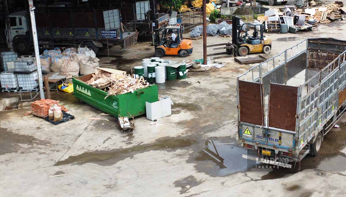 Các xe chở rác thải gắn biển tên công ty môi trường trong cơ sở xử lý rác thải công nghiệp trái phép. Ảnh: PV.