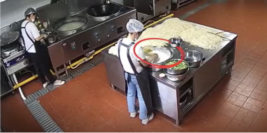 Nhân viên nhà bếp trường mẫu giáo Bồi Tín, tỉnh Cam Túc, Trung Quốc thêm bột màu vào thực phẩm. Ảnh: Cắt từ video của CCTV