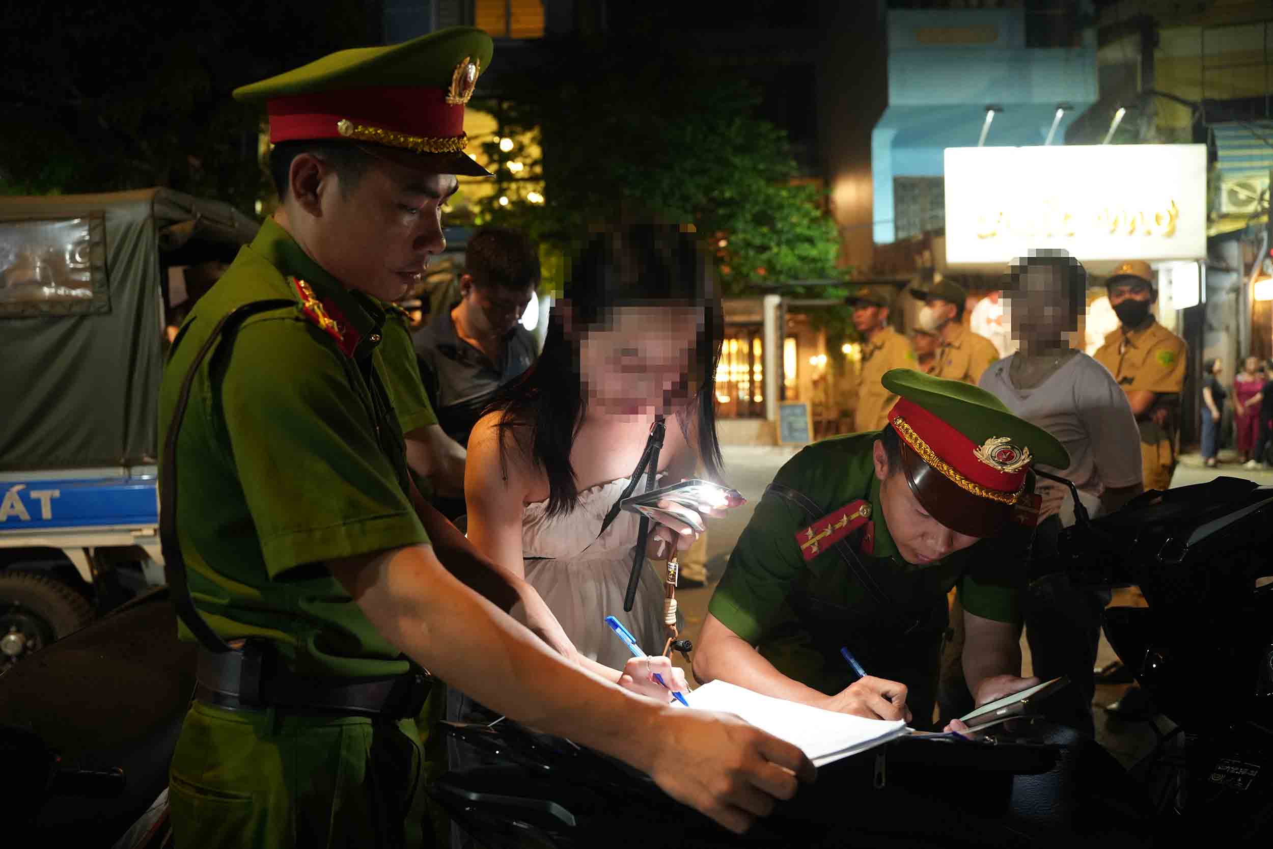 Lực lượng chức năng lập biên bản một trường hợp dừng đỗ xe sai quy định trên phố Mai Anh Tuấn, chiều tối 17.7. Ảnh: Hữu Chánh
