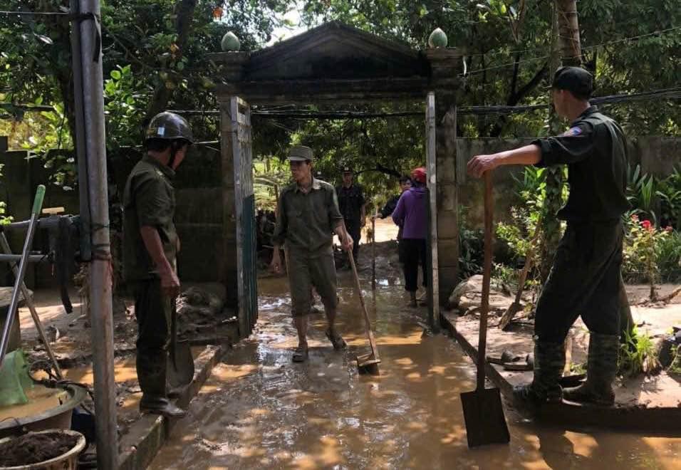 Lực lượng công an, cán bộ cơ sở Lào Cai giúp dân dọn dẹp sau ngập lụt. Ảnh: Quỳnh Trang