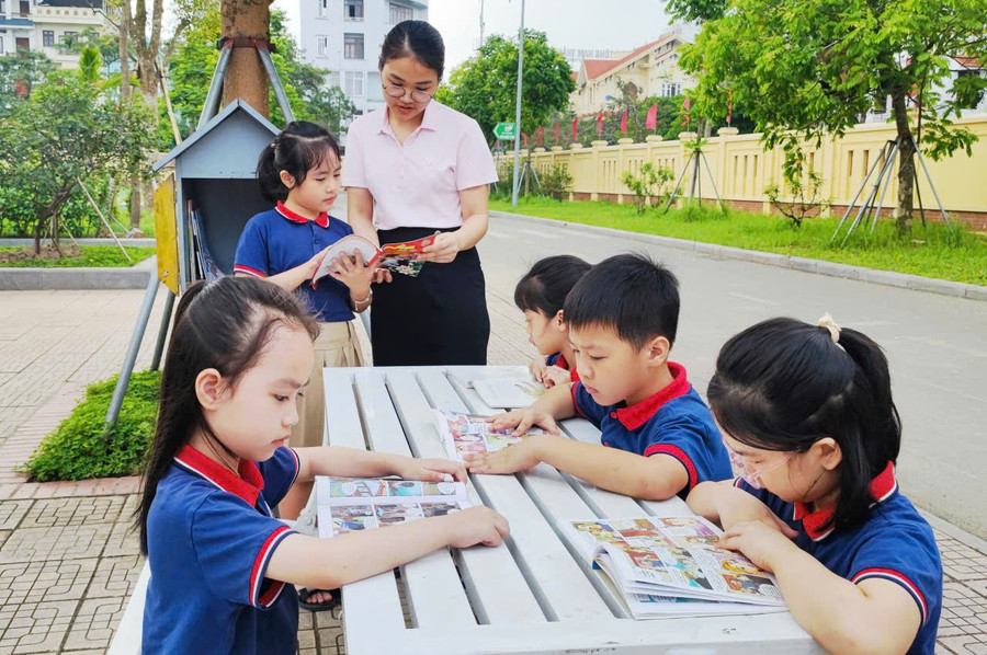 Học sinh Trường Tiểu học Trần Nhân Tông (Đông A, Ninh Bình) trong buổi ngoại khóa - đọc sách ngoài trời. tran-nhan-tong.jpg