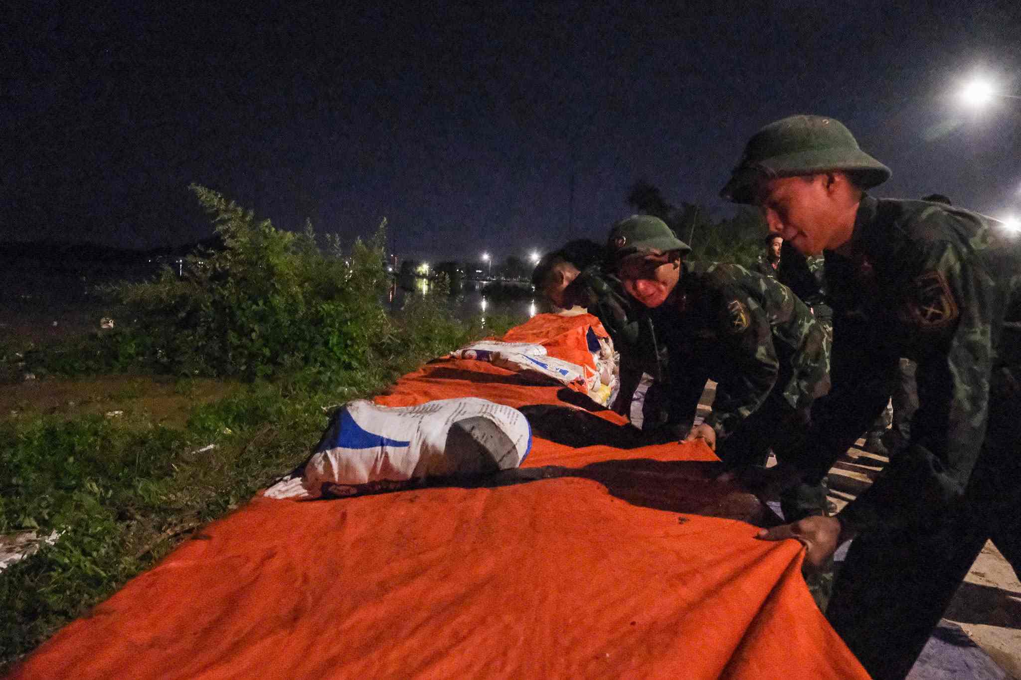 Lực lượng chức năng và người dân gia cố đê bối Đẩu Hàn, phường Kinh Bắc, Bắc Ninh, tối 8.10. Ảnh: Vân Trường