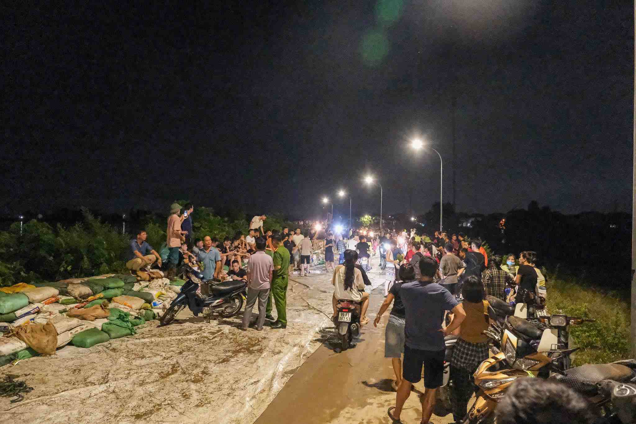 Người dân tham gia công tác hộ đê cùng lực lượng chức năng tại đê bối Đẩu Hàn, phường Kinh Bắc, tỉnh Bắc Ninh, tối 8.10. Ảnh: Vân Trường