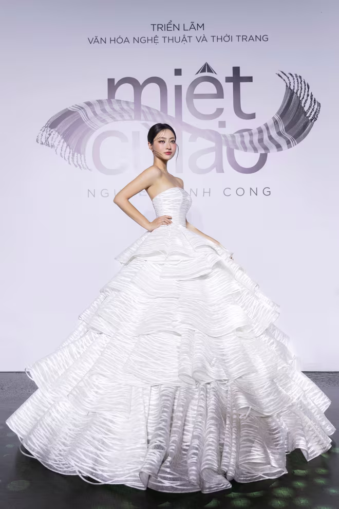 Hoa hậu Lương Thùy Linh khép lại sàn diễn với “Bánh tráng rế”. Lớp ren tone trắng được thiết kế từng tầng cùng độ cong mềm đặc trưng tạo nên vẻ ngoài bồng bềnh, thướt tha và sang trọng của thiết kế Hoa hậu Lương Thùy Linh khép lại sàn diễn với “Bánh tráng rế”. Lớp ren tone trắng được thiết kế từng tầng cùng độ cong mềm đặc trưng tạo nên vẻ ngoài bồng bềnh, thướt tha và sang trọng của thiết kế