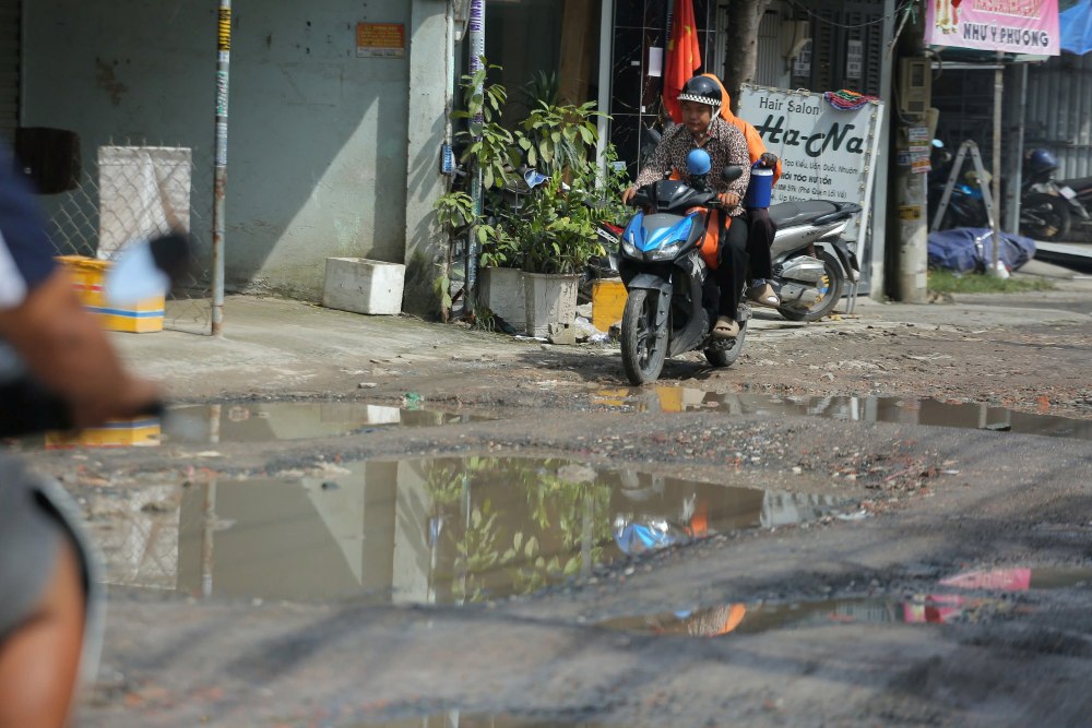 Đường lồi lõm, tạo hố sâu, mưa xuống gây ngập, người dân di chuyển khó khăn. Ảnh: Minh Tâm