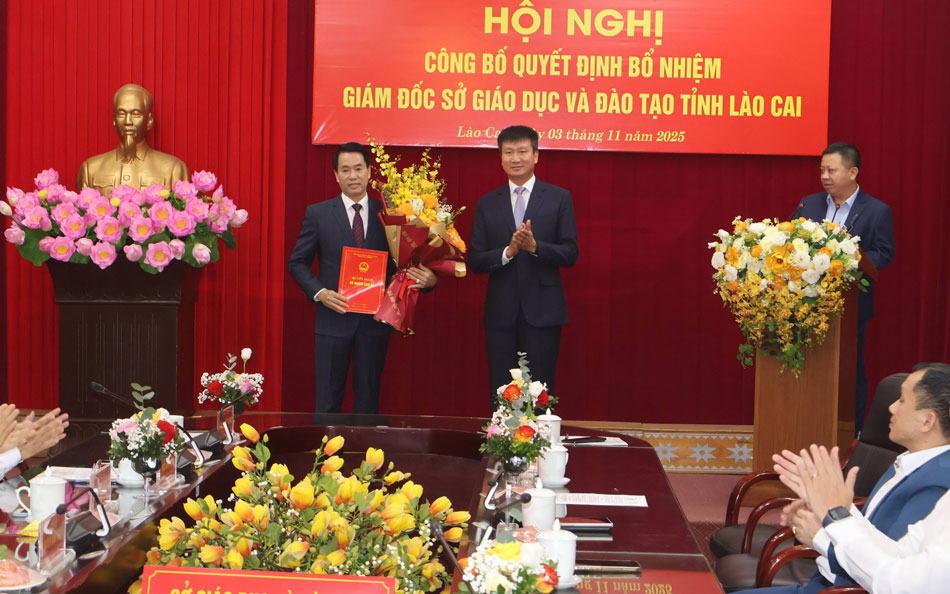 Ông Trần Huy Tuấn - Chủ tịch UBND tỉnh Lào Cai trao Quyết định và tặng hoa chúc mừng tân Giám đốc Sở Giáo dục và Đào tạo tỉnh Lào Cai.