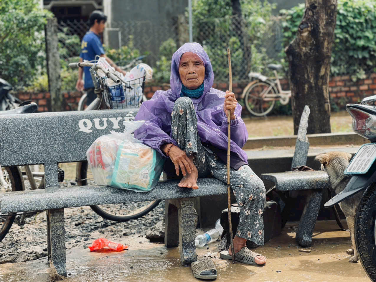 Ánh mắt người bà sau mưa lũ — sâu và buồn như chính những gì đã bị cuốn đi, khiến người nhìn cũng thắt lòng chua xót.