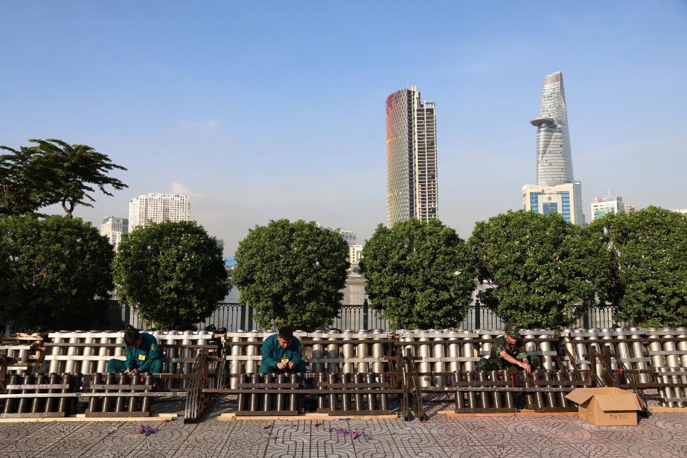 Lực lượng kỹ thuật lắp đặt, cố định giàn pháo hoa tại khu vực đầu hầm sông Sài Gòn trước giờ bắn. Ảnh: Thái Bảo