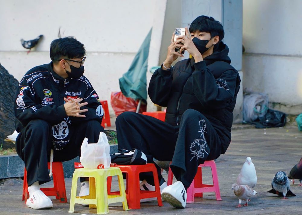 ranh thủ cái lạnh hiếm hoi, nhiều bạn trẻ xúng xính diện áo len, mũ beret sành điệu ra quán cà phê trung tâm để check-in. Ảnh: Thái Bảo